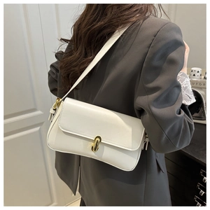 Detailed side view of white baguette shoulder bag with gold oval lock on female model