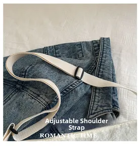 Détail de la bandoulière réglable en toile blanc cassé sur un sac à bandoulière en jean