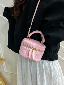 Pink quilted leather mini vanity bag with chain strap shown on model's shoulder