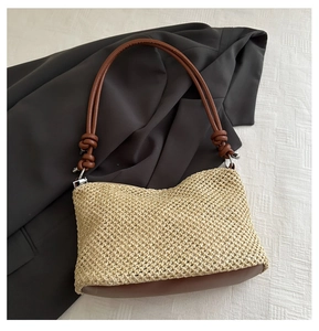 Dettaglio dell'intreccio su borsa a spalla in paglia beige con manico in pelle marrone
