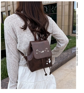 Close-up of vintage brown PU leather backpack with cute cartoon cat print details