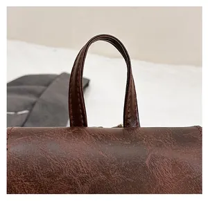 Close-up of high-quality brown textured leather handle and fine stitching on backpack