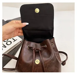 Detail view of the vintage brown faux leather backpack showing the durable magnetic snap closure