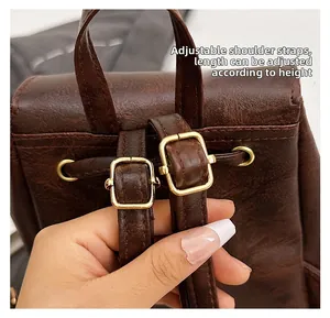 Detail of adjustable leather backpack straps with gold metal buckles for customized length