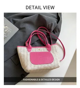 Detail der Strohtasche mit pinkem Lederbesatz und strukturierter Tasche auf grauem Stoff