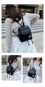 Detail view of mini black PU leather cat backpack with drawstring and flap closure