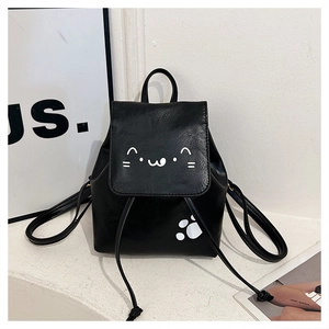 Detail of a black mini PU leather backpack featuring a cute white cartoon cat face design