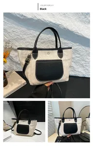 Detail der gewebten Stroh-Tote-Bag mit schwarzen Lederakzenten und verstellbarem Riemen