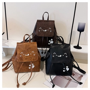 Detailed view of three cat-shaped PU leather mini backpacks in black and brown tones