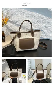 Detailansicht der gewebten Stroh-Tasche mit braunem Lederbesatz und verstellbarem Schultergurt