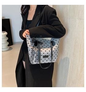 Dettaglio della borsa tote a pois con grande fiocco in pizzo nero e tracolla