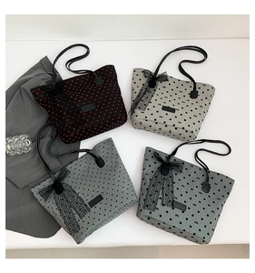 Vue détaillée de sacs cabas à pois avec nœud en dentelle décoratif et fines bandoulières