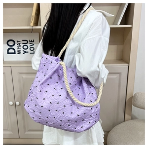Detail of purple tote bag with bow embroidery and cream rope shoulder strap knots