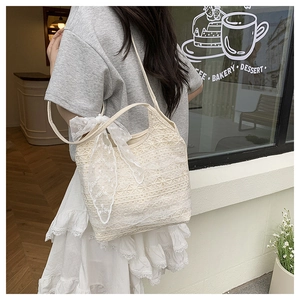 Detailed lace embroidery and bow ribbon on a cream off-white mesh tote bag for women