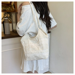 Detailed close-up of a beige floral lace crochet tote bag showing delicate hollow textures