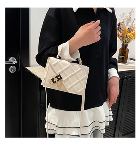 White quilted crossbody bag with gold chain strap and lock shown on a female model