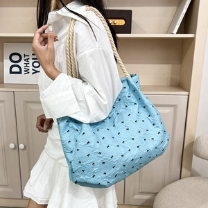 Light blue pleated tote bag with black bow patterns and thick cotton rope shoulder strap