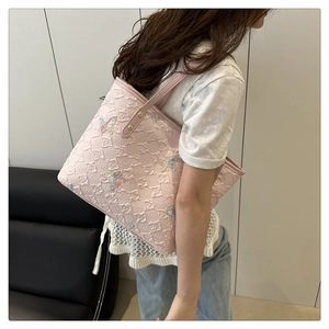 Detail of pink tote bag with embossed letters and colorful butterfly prints