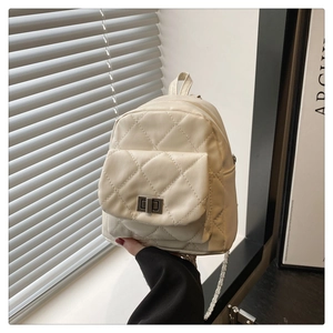 Close-up of cream quilted leather mini backpack with metal chain straps and twist lock