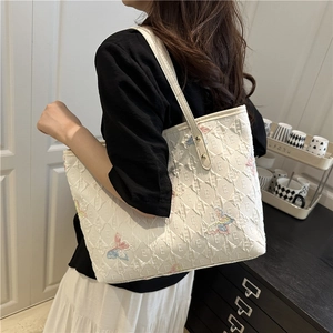 White quilted tote bag with colorful butterfly embroidery and shoulder strap for women
