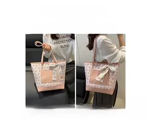 Pink tote bag detail showing dual carry options with a decorative floral ribbon accent