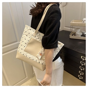 Detail of a large pink and cream tote bag with patterned fabric shown on shoulder