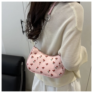 Détail du sac hobo rose avec imprimés cerises et bandoulière chaîne et cuir argent