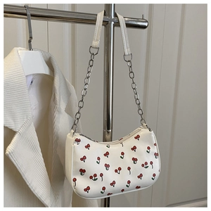 Detail of white baguette bag with cherry print and metallic chain strap on hanger