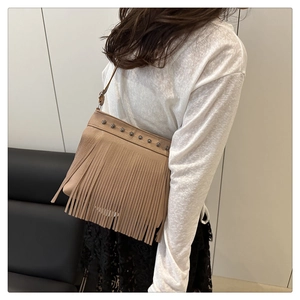 Sac bandoulière en similicuir beige à franges avec clous argentés sur un mannequin