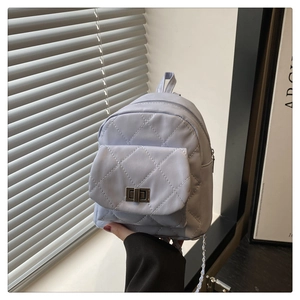 Detail showing lavender quilted mini backpack with silver metal twist lock and chain strap