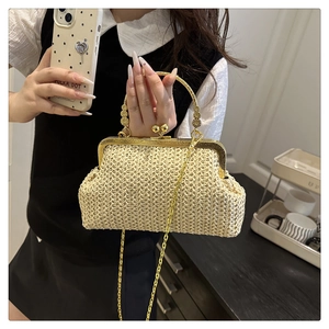 Détail du sac tissé crème vintage avec poignée dorée ornée et bandoulière en chaîne