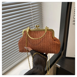 Detail of woven straw handbag featuring vintage gold clasp and elegant ring handle