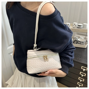 Detail showing white woven texture handbag with dual golden zippers and slim strap