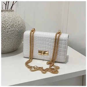Detailed view of white patent leather crossbody bag with crocodile pattern and gold twist lock