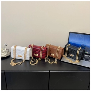 Close-up of four luxury crocodile pattern square bags in white, red, brown, and black colors