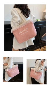 Detail of pink denim tote bag featuring white lace trim and artistic typography