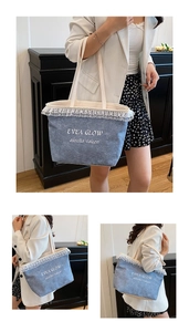 Close-up of the delicate white lace trim and embroidered EVEA GLOW logo on blue denim tote