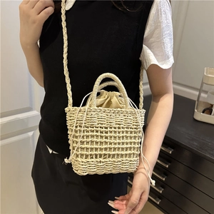 Handmade woven straw bucket bag with drawstring closure and shoulder strap for summer