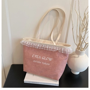 Detailed view of pink canvas tote bag featuring white lace trim and Evea Glow print