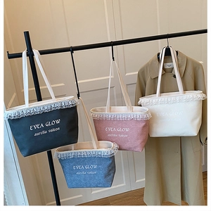Lace-trimmed denim tote bags in four colors hanging on a display stand in a room