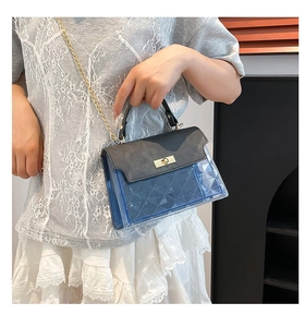Blue quilted PVC crossbody bag with black flap and gold chain strap shown on a model