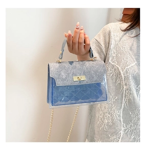 Detail of blue quilted PVC bag with gold metal twist lock and textured silver flap