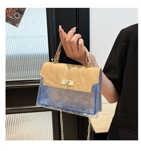 Detail of blue transparent PVC crossbody bag with khaki trim and gold metal lock