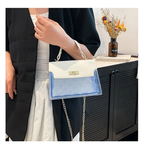 Detail of blue transparent PVC tote with rhombic pattern and golden metal turn-lock closure