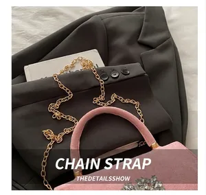 Detail of pink suede bag featuring luxury cluster rhinestones and gold chain strap