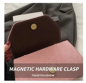 Detail showing pink suede bag with round gold magnetic buckle and brown interior