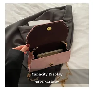 Internal capacity display of pink suede chain bag showing space for phone and wallet