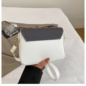Détail du sac bandoulière avec rabat en toile grise et texture en cuir synthétique