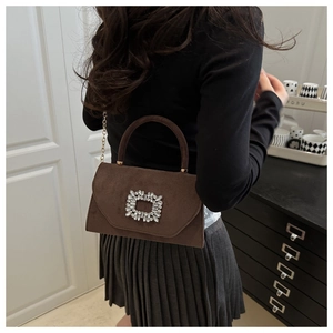 Détail du mini sac en daim marron avec boucle en cristal et bandoulière chaîne