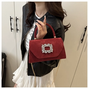 Detail of burgundy matte handbag with a large square rhinestone buckle and golden chain